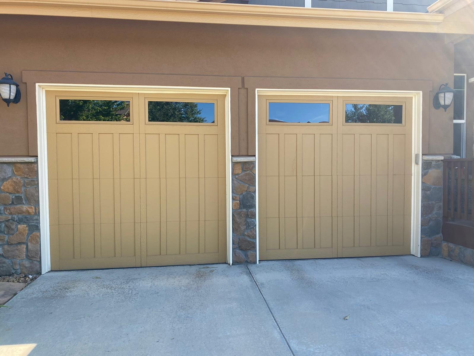 Residential garage doors | WE FIX IT Garage Door Repair Two residential garage doors with upper windows and decorative panels