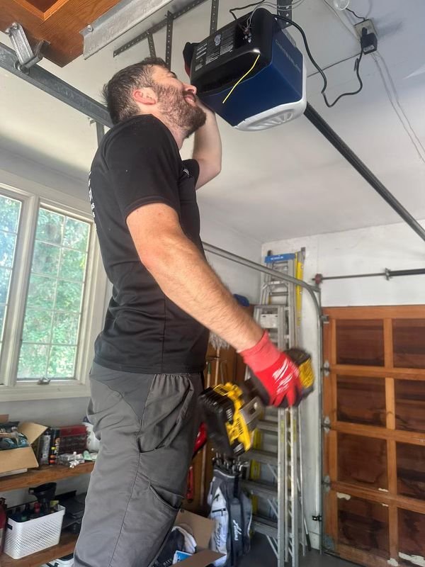 Garage Door Opener Service | WE FIX IT Garage Door Repair Garage door technician inspecting an overhead opener motor and rail