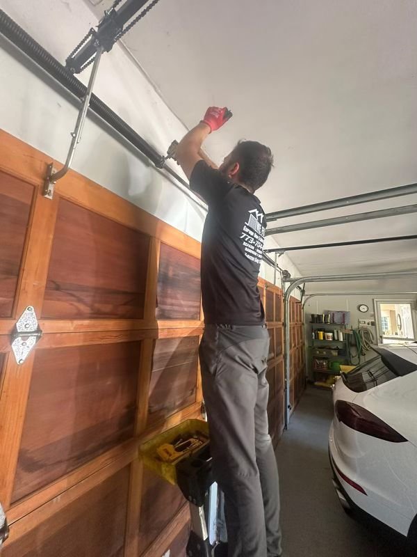 Garage Door Spring Repair | WE FIX IT Garage Door Repair Garage door technician inspecting the spring and overhead hardware